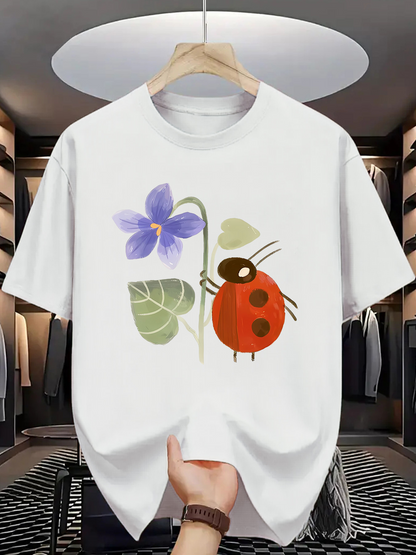 Men's Graphic T-Shirt Whimsical Garden Flower With Leaves Beside A Playful Red Ladybug